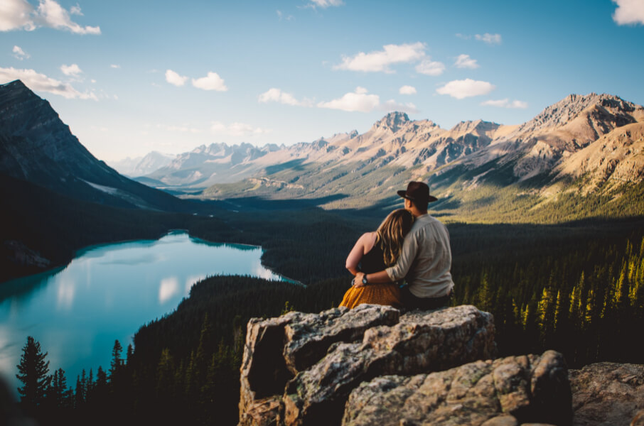 Couple sitting on a mountain looking at a lake
